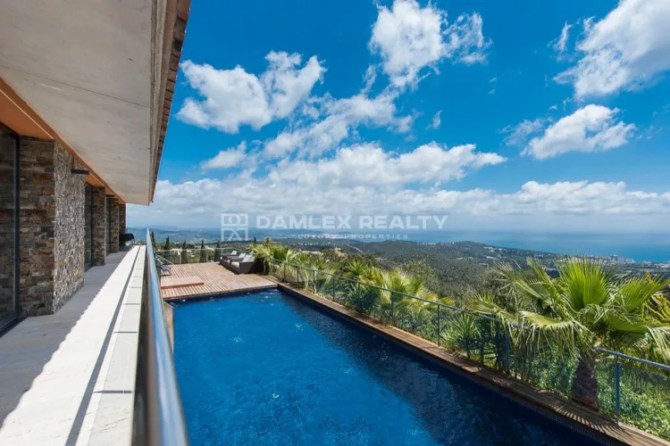 Modern villa with panoramic sea and mountain views in the prestigious Mas Nou urbanization, just minutes from the golf course.
